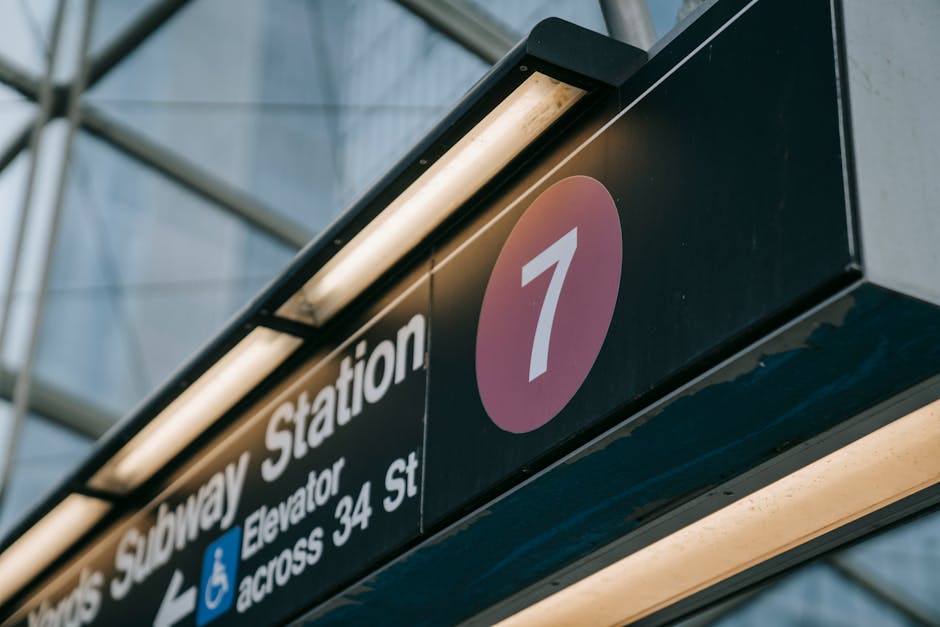 Close-up of a subway station sign with the number seven, located in New York City.