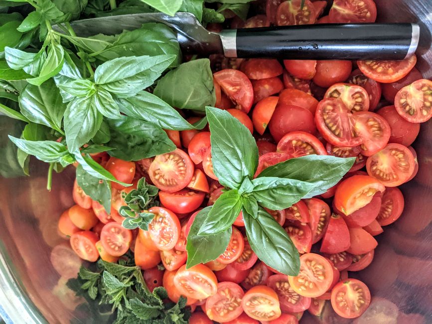 A vibrant arrangement of fresh basil, sliced tomatoes, and herbs, perfect for a healthy me