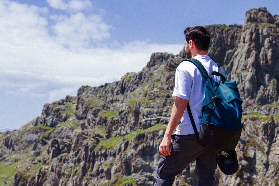 A hiker with a backpack explores the rocky landscape of Gümüşhane, Türkiye on a sunny day.