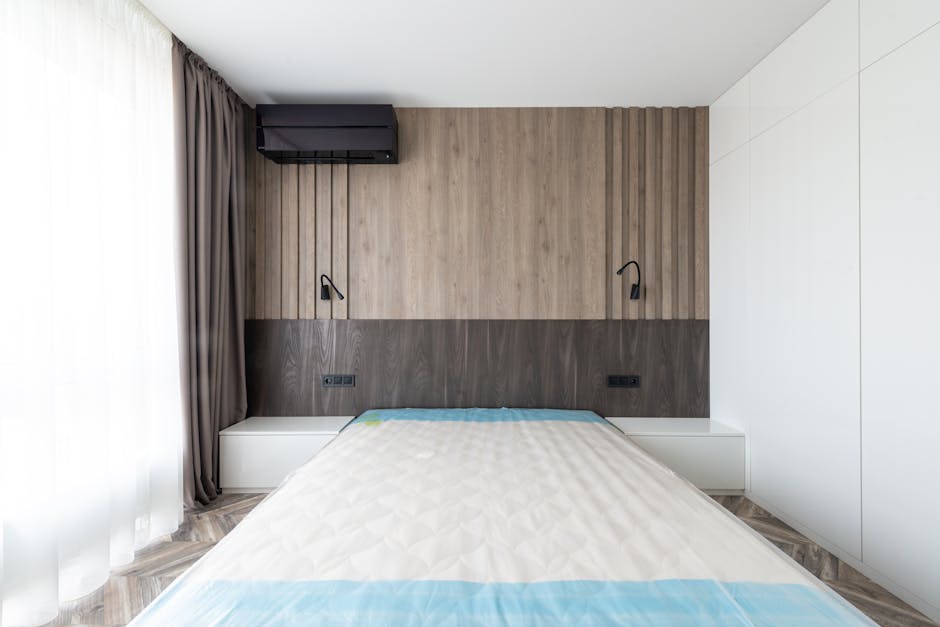 Sleek and modern bedroom featuring a minimalist design with wooden paneling and neutral tones.
