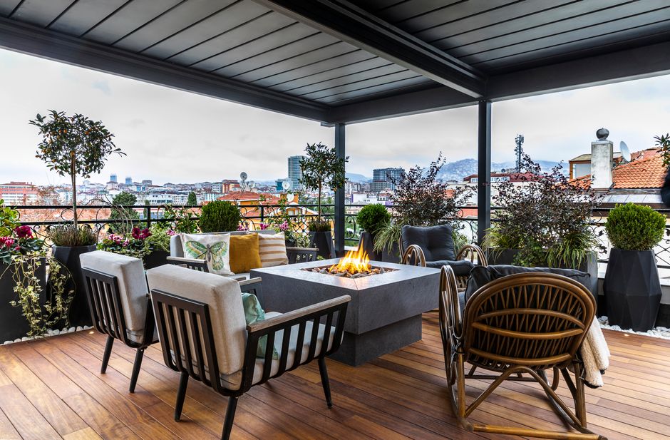 Cozy terrace with fireplace, seating, and city view. Perfect for relaxing evenings.