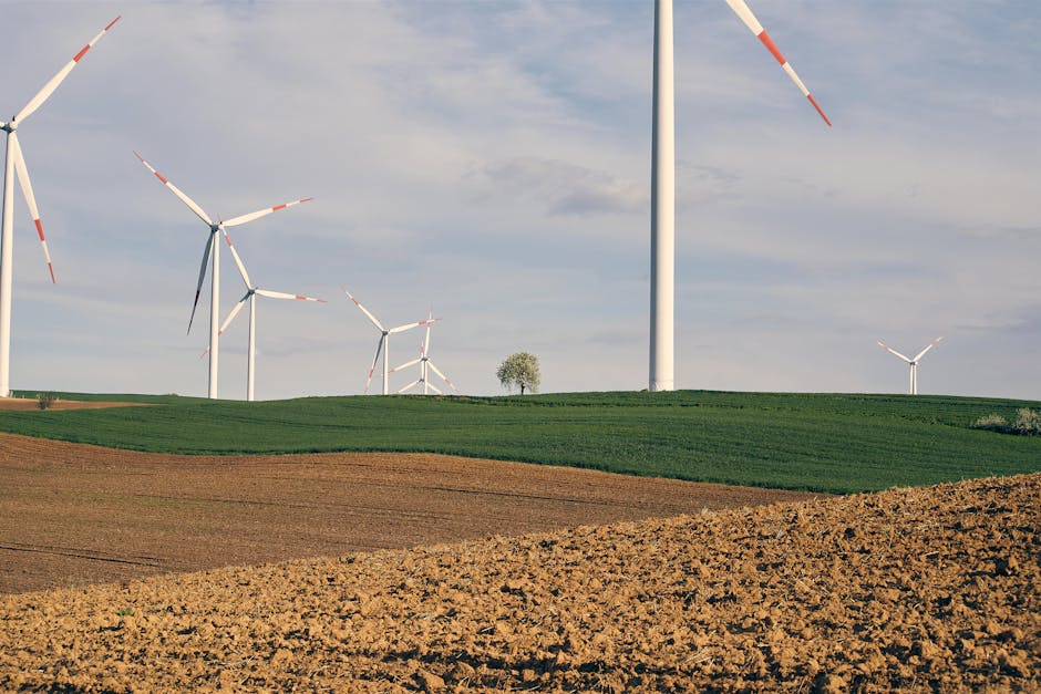Wind turbines on rolling green hills under a clear sky, showcasing clean energy technology.
