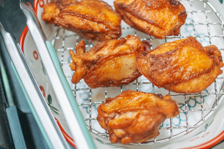 Golden brown fried chicken pieces cooling on a wire rack, perfect for a delicious meal.