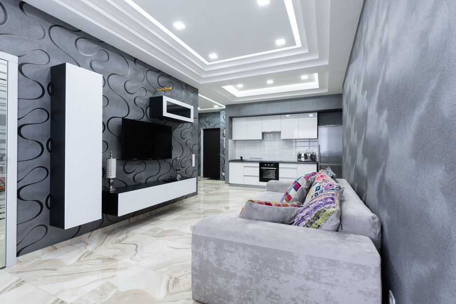 Interior of contemporary living room with comfortable sofa with colorful pillows and gray walls in luxury apartment